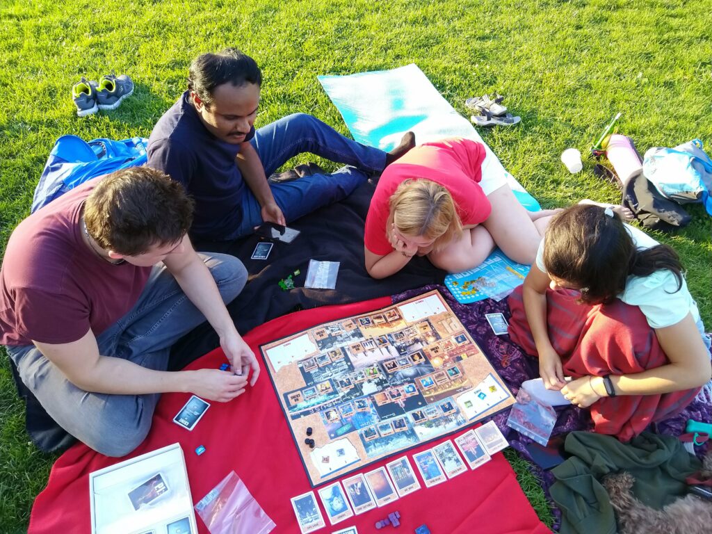 Students playing English board games while learning English in park in Brno